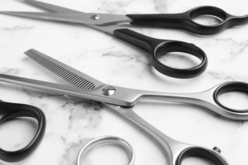 Scissors on marble background, closeup. Hairdresser tools
