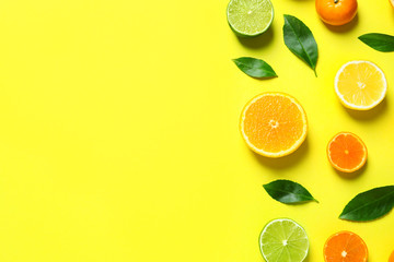 Different citrus fruits and leaves on color background, flat lay. Space for text