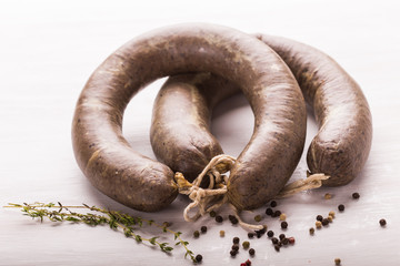 Food, meat and delicious concept - sliced horse meat sausage with cumin