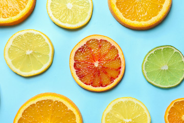 Fototapeta na wymiar Different citrus fruits on color background, flat lay