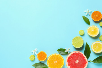 Frame made of different citrus fruits and leaves on color background, flat lay. Space for text