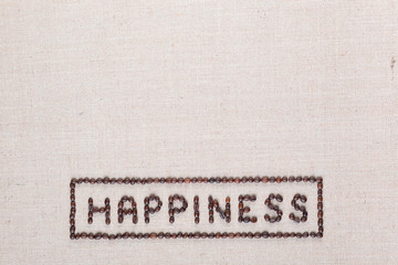 Fototapeta na wymiar Happiness sign from coffee beans on linea texture, aligned bottom center.