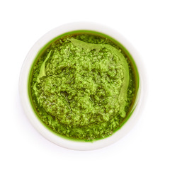 Bowl of tasty pesto sauce isolated on white, top view
