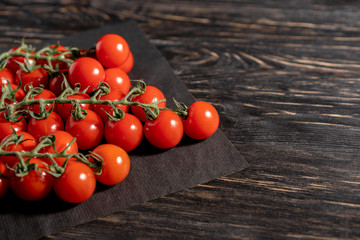 Cherry tomatoes in the paper packaging on the wooden table