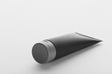 Black tube with space for design on white background. Men's cosmetic product