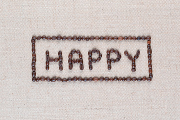 Happy sign from coffee beans on linea texture, close up.