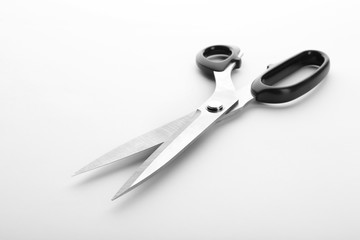 Pair of sharp sewing scissors on white background