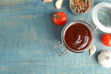 Flat lay composition with barbecue sauce on blue wooden table. Space for text