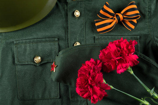 Concept for postcard for the holiday of victory: military uniform and red carnations background