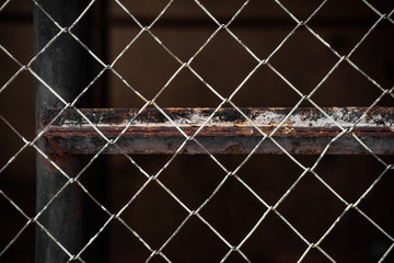 Old metal mesh fence and rusty beam