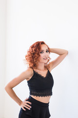 People and fashion concept - Redhead model posing over white wall background