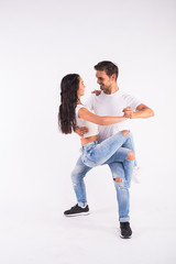 Young couple dancing social dance bachata, merengue, salsa, kizomba. Two elegance pose on white room.