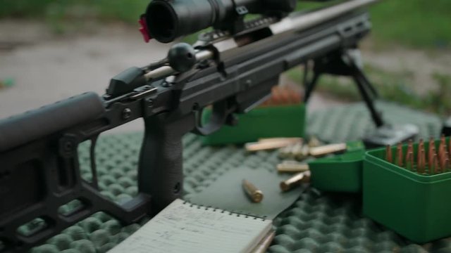 Sniper rifle. Position for shooting. Slow Motion. 4K.