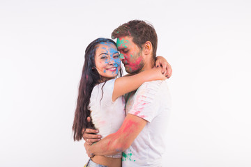 Festival of holi, friendship - young people playing with colors at the festival of holi on white background