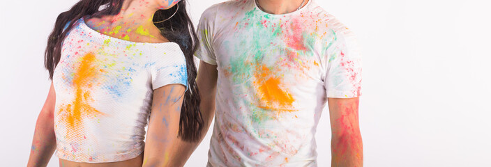 Holiday, holi and people concept - Happy couple having fun covered in paint on white background