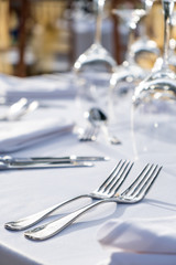 Elegant table setting: white plates with white linen and silverware. Weddingor festive dinner table set up