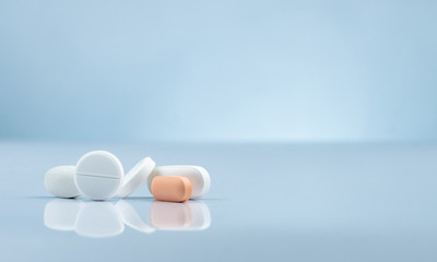 Pharmacy drugstore product. Pile of orange and white tablets pill on gradient background. Different size and shape tablets pills. Pharmaceutical industry. Medicine in hospital. Retail drug market.