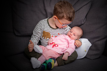 Bruder hält neugeborene Baby Schwester in den Armen Porträt