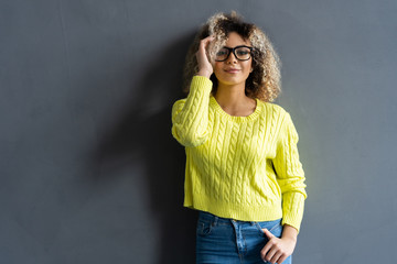 Portrait of young beautiful cute cheerful black girl smiling looking at camera over gray background.