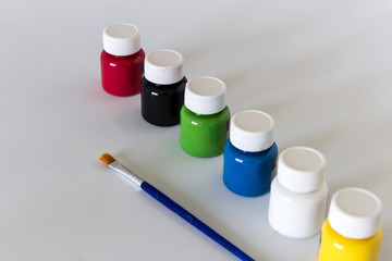 Bottles with colors and brush on white background