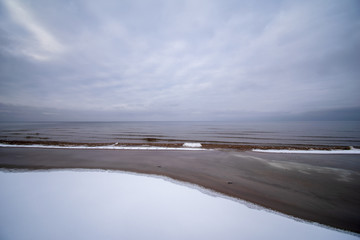 ice frozen sea beach with snow and frozen trees