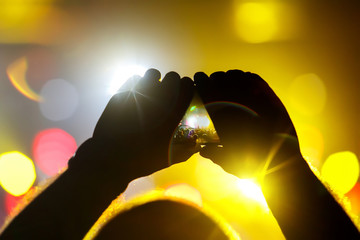 Shoots an instagram video on a mobile phone at a concert