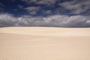 Fototapeta na wymiar Bright shining white edge of sand dune contrasting against deep blue sky, Corralejo, Fuerteventura, Canary Islands