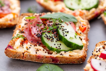 Sandwiches with cream cheese, vegetables and salami.