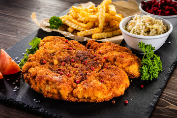 Fried pork chop, French fries and vegetable salad
