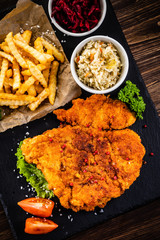 Fried pork chop, French fries and vegetable salad
