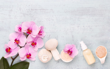 Sea salt, aromatherapy oil in bottles and orchid on vintage wooden background.