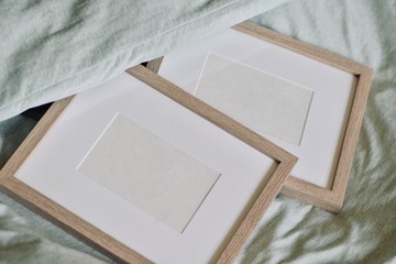 Mockup-template. Single wooden photo frame in pastel green bed. Frames with white copy space, cozy feeling ideal for furniture/decoration shoot-outs.