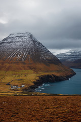 View from Kap Enniberg towards the small village Viðareiði, Viðareiði kirkja, its fjord and snow-covered mountains (Faroe Islands, Denmark, Europe)