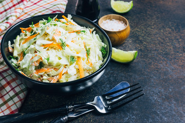 Traditional cole slaw salad in a black bowl