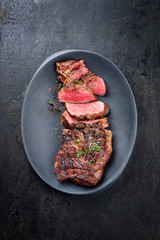 Barbecue dry aged wagyu tri tip steak sliced as top view in a modern design cast iron plate