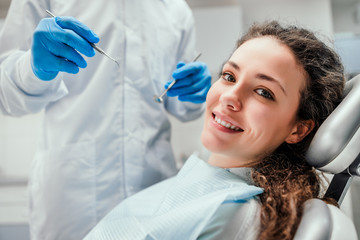 Smiling young woman receiving dental checkup. close up view. Healthcare and medicine concept. - obrazy, fototapety, plakaty