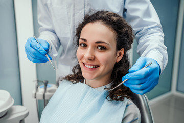Dentist examining a patient's teeth in the dentist chair. Healthcare and medicine concept.