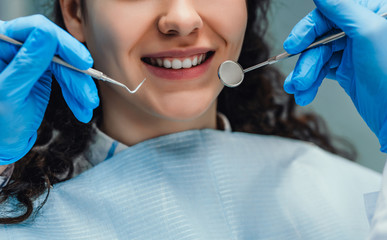 The woman came to see the dentist. She sits in the dental chair. The dentist bent over her. Happy...