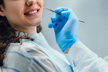 Close up of woman having dental check up in dental office. Dentist examining a patient's teeth with...
