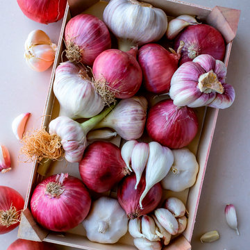 Young garlic and red onions in a vegetable box. Concept- organic vegetables, healthy food.