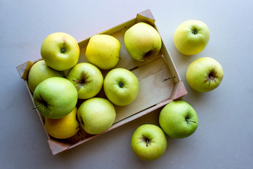 Green apples in a wooden crate. Concept- fresh organic fruit, healthy food from garden. Selective focus.