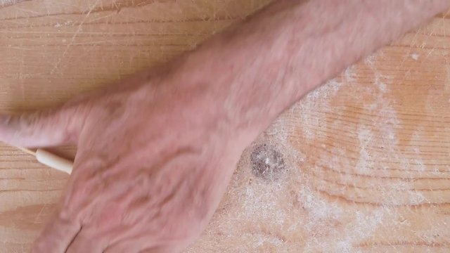 Pasta fatta in casa su un tagliere di legno con farina bianca e integrale.