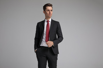 relaxed man stepping with hand in pocket while looking up