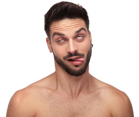 Fototapeta premium goofy naked man fooling around rolling his eyes, exposing tongue