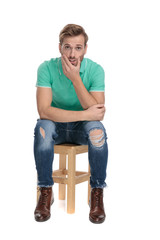 seated surprised man thinking with hand at chin