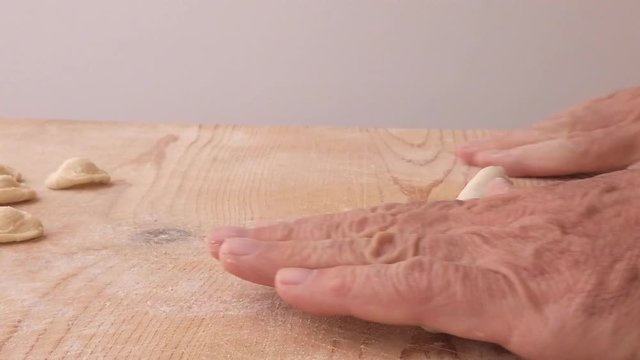 Pasta fatta in casa su un tagliere di legno con farina bianca e integrale.