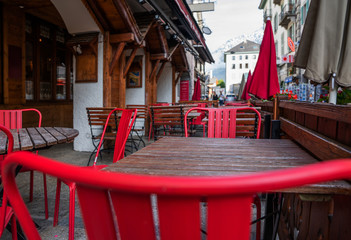 View of old street in Chamonix village, France. Cozy cityscape.Typical view of the street with tables of cafe in Chamonix.