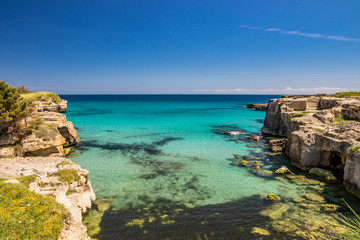 The important archaeological site and tourist resort of Roca Vecchia, in Puglia, Salento, Italy. Turquoise sea, blue sky, rocks, sun, lush vegetation in summer. Basiliane Caves (VIII century)