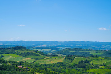 Obraz premium Beautiful landscape of vineyards. Chianti region in summer season. View of countryside and chianti vernaccia vineyards from San Gimignano. Tuscany, Italy, Europe. Summer, holiday, traveling concept.