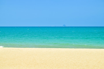 Stripes of blue sky and green ocean and yelllow sand on beach